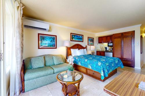 卡帕阿Islander on the Beach 333的一间卧室配有一张床、一张沙发和一张桌子