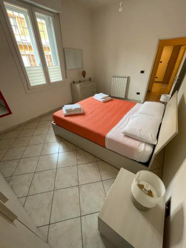 博洛尼亚FEELS LIKE HOME的一间卧室配有带橙色床单的床和窗户。