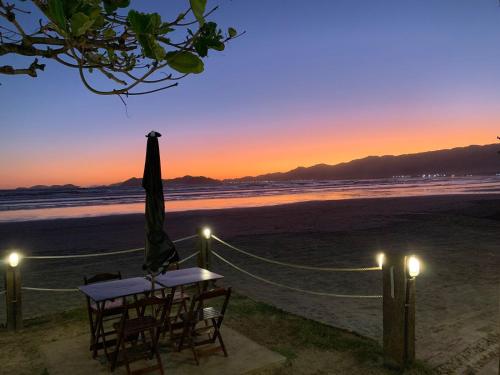 伯迪亚哥Pousada Jolly Roger的日落时在海滩上摆放桌椅