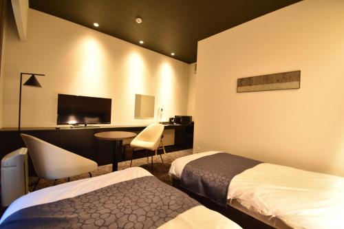ShimmachidōriK-style gosyonishi的酒店客房配有两张床和一张书桌