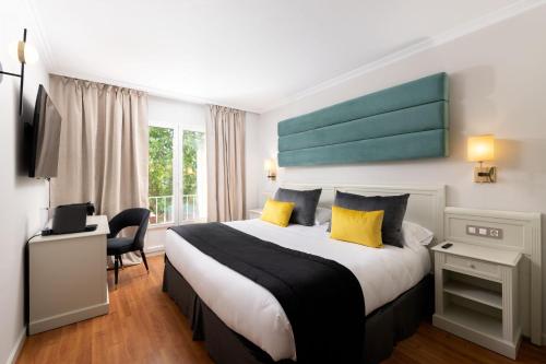 希洪1907 VILLA GIJON的酒店客房配有一张带黄色枕头的大床