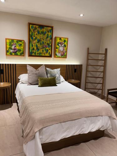 马萨米特拉Cabaña QUINTA GAES SPA的卧室配有一张白色大床,墙上挂有绘画作品