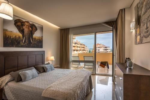 索托格兰德Sotogrande - Ribera del Marlín的一间卧室设有一张床,享有阳台的景色