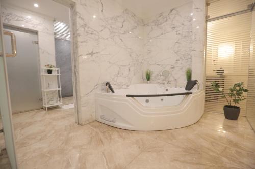 塔伊夫برود的白色的浴室设有浴缸和水槽。