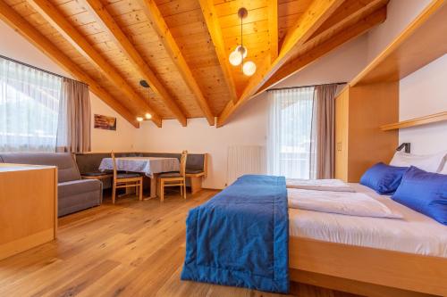 圣坎迪朵Alpengruss的一间卧室配有一张床、一张沙发和一张桌子