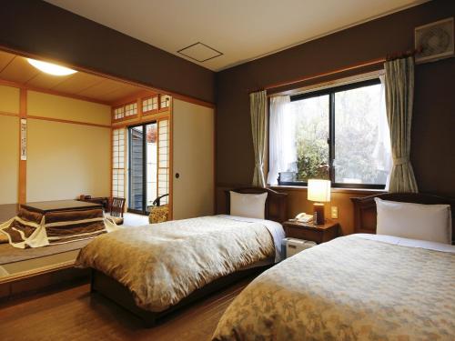 高山游传统日式旅馆的一间卧室设有两张床和窗户。