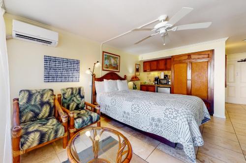 卡帕阿Islander on the Beach 361的卧室配有1张床、1张桌子和1把椅子
