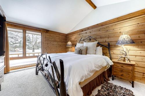 提顿村Golf Creek12的卧室设有木墙、一张床和窗户