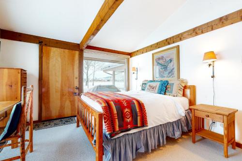 提顿村The Director's Cabin的一间卧室设有一张床和一个窗口