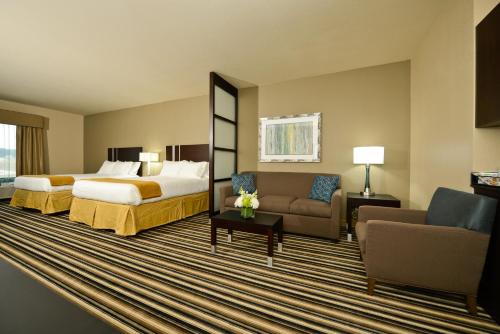 福雷斯特城Holiday Inn Express & Suites Forrest City, an IHG Hotel的酒店客房,配有床和沙发