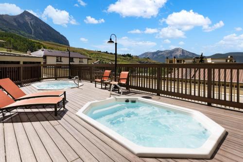Mount Crested Butte艾勒维申温泉酒店的两把椅子旁甲板上的热水浴池