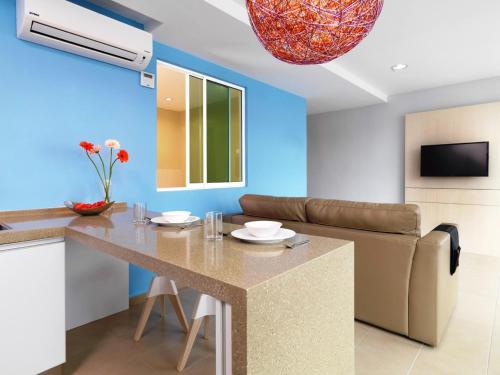 马六甲菲尼西客栈酒店的厨房以及带桌子和沙发的客厅。