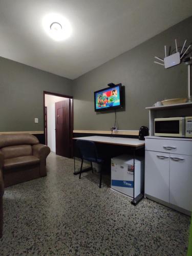 弗赖本托斯Suculento Apart的客厅配有书桌和沙发。