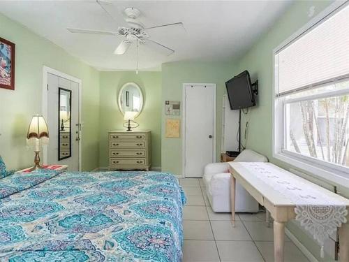 萨拉索塔Charming Studio Unit Across from Lido Key Beach的一间卧室配有一张床、一张桌子和一个窗户。
