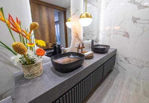亚美尼亚Hotel Casa Giraldo的浴室在花卉柜台上设有两个水槽