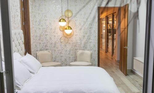 亚美尼亚Hotel Casa Giraldo的卧室配有白色的床和吊灯。