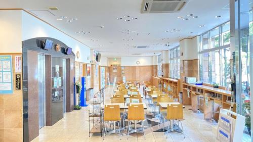 松山Toyoko Inn Matsuyama Ichibancho的一间设有桌椅和窗户的自助餐厅