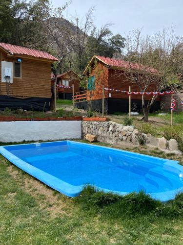 圣阿方索Cabañas Between Hills的房子前面的蓝色游泳池