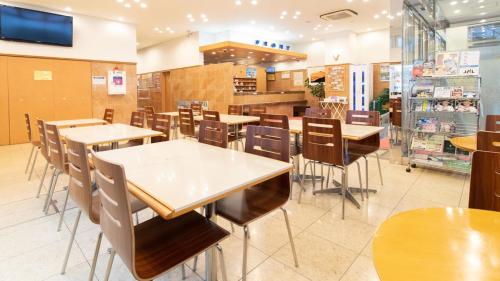 苫小牧市Toyoko Inn Hokkaido Tomakomai Ekimae的一间位于商店的带桌椅的用餐室