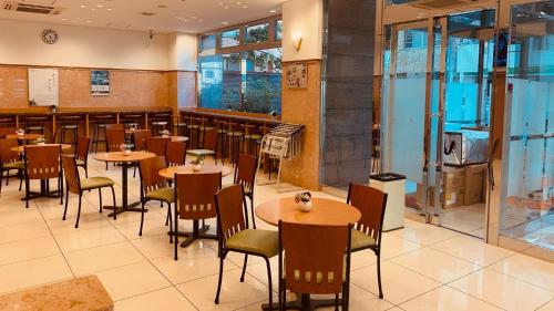 热海热海站前东横旅馆(Toyoko Inn Atami Ekimae) 的一间带桌椅的餐厅和一间酒吧