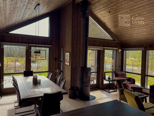SvingvollModern unique cabin fantastic location Skeikampen的一间带桌椅和窗户的用餐室