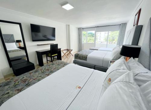 圣玛尔塔Hotel Arhuaco Rodadero的酒店客房设有两张床和一台平面电视。