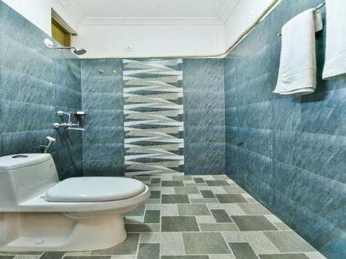 莫尔吉姆Pappi Chulo Morjim的一间带卫生间的浴室和蓝色瓷砖墙壁。