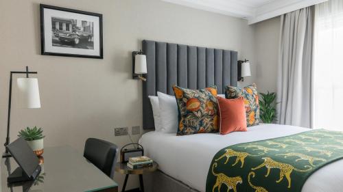 泰晤士河畔里士满The Selwyn, Richmond的配有一张床和一张书桌的酒店客房