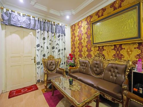 名古屋OYO 91782 Satria Homestay Syariah的客厅配有沙发和桌子