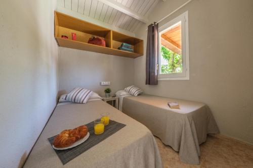 科马鲁加万德雷利普拉佳露营地的配有两张床铺的房间,包括一盘羊角面包