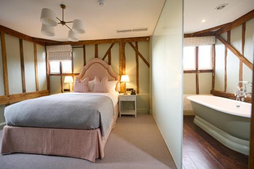 斯托克拜奈兰德The Angel Inn, Stoke-by-Nayland的一间卧室配有一张床和浴缸