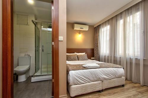 伊斯坦布尔Wide Suites Taksim的一间卧室设有一张床、淋浴和卫生间