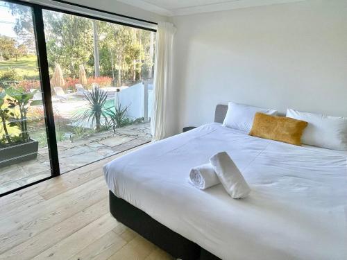 拜伦湾Coral villa的一间卧室配有一张大床和两条毛巾