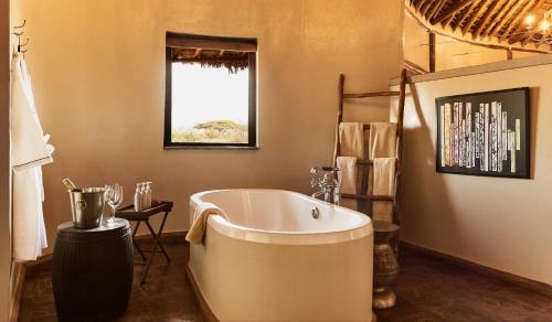 安博塞利塔威山林小屋的一间带大浴缸和窗户的浴室