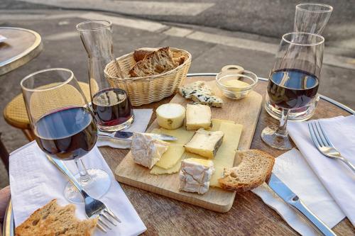 诺伊斯·勒·格兰德老井住宿加早餐旅馆的桌子上放着葡萄酒和奶酪