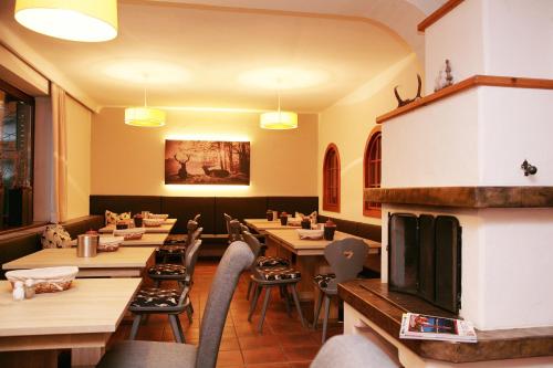 滨湖采尔Lake and Cityhotel Edelweiss - self Check in的餐厅设有木桌、椅子和壁炉