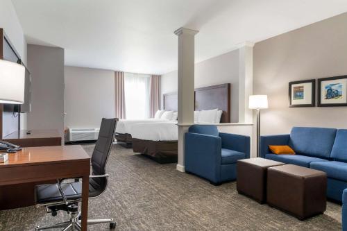 帕迪尤卡Comfort Suites的酒店客房,配有一张床、一张桌子和椅子