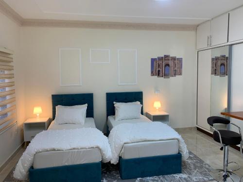 杰拉什Tayoon Host的一间卧室配有两张床和两盏灯。