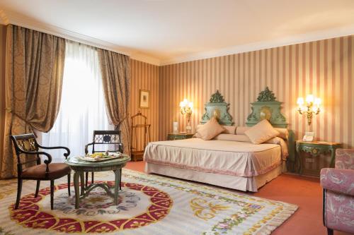 奥维多欧洲之星复国酒店的卧室配有1张床、1张桌子和1把椅子