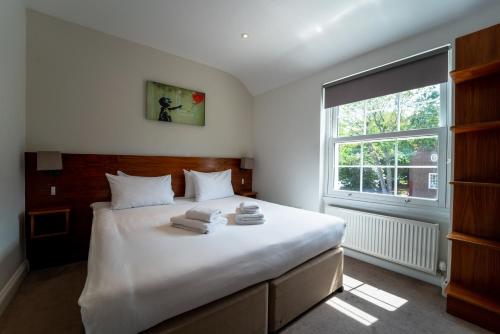 伦敦切尔西宾客别墅酒店的卧室配有一张大白色床和窗户