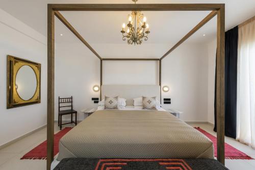纳乌萨Kallisti Paros的一间卧室配有一张带吊灯的天蓬床