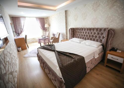 伊斯肯德伦巴亚兹特酒店的一间卧室,卧室内配有一张大床