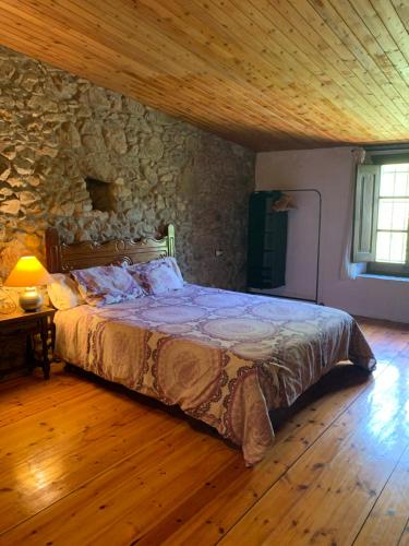 莫奈斯Can Carreras的一间卧室设有一张床和石墙