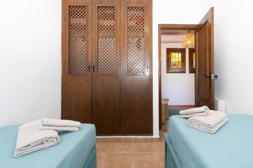 弗拉门卡海滩228 Lovely Home La Zenia - Alicante Holiday的一间设有两张床的客房和一个带毛巾的门