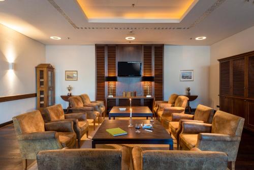 巴特萨罗皮斯库夫Precise Resort Bad Saarow - Golf & Spa的客厅配有椅子、桌子和电视