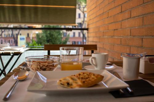 罗马B&B JONIO Roma的一张桌子,上面放着一盘食物和一杯橙汁
