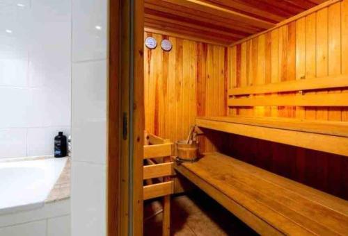 巴斯Artist's Retreat - Old Signal Box - Private Sauna的一间带木墙和木板凳的桑拿浴室