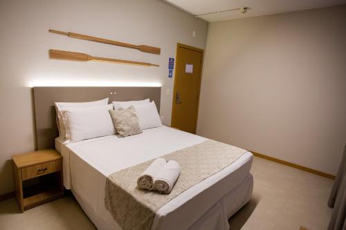弗洛里亚诺波利斯卡纳斯维尔莱斯海酒店的卧室配有带毛巾的大型白色床