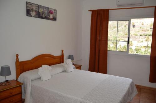 巴耶格兰雷伊瓜达乡村民宿的一间卧室配有一张带白色床单的床和一扇窗户。
