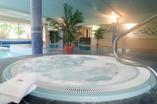 罗斯康芒阿比洛斯康姆酒店的热水浴池位于带游泳池的客房中间